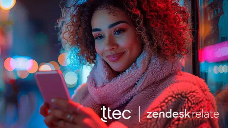 Woman wearing a scarf smiling while looking at her phone