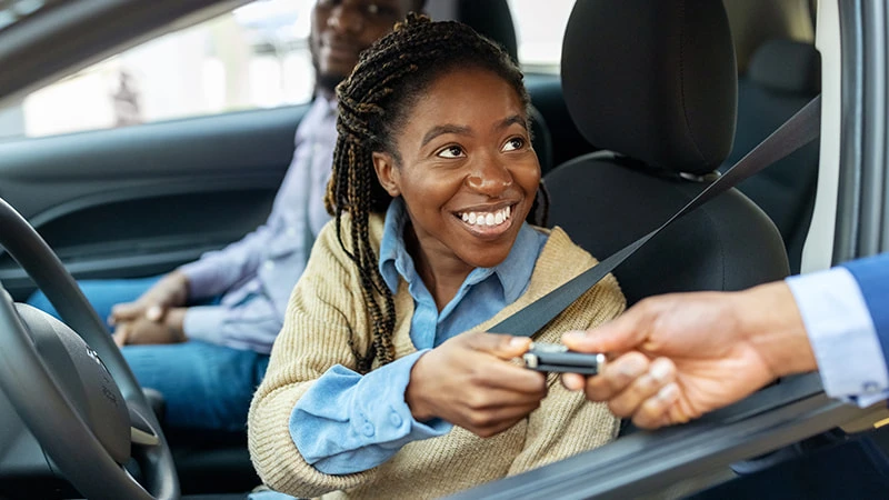 A woman being handed the keys to her new car