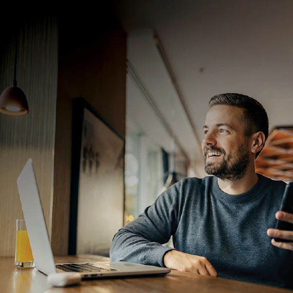 Man talking on speakerphone at his desk