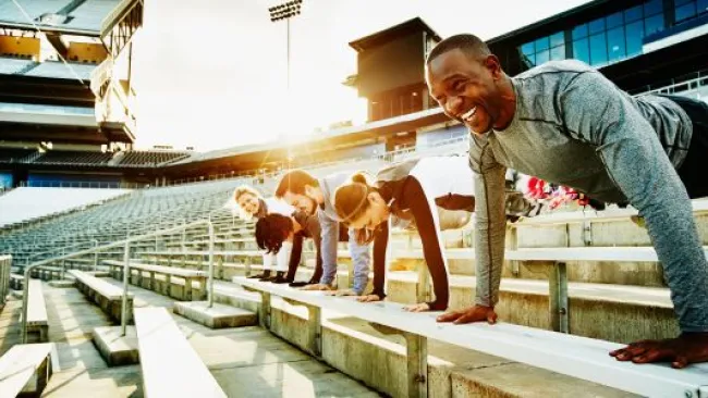 Team doing push ups in a stadium