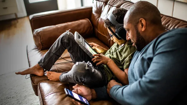 Father and son enjoying entertainment on the couch