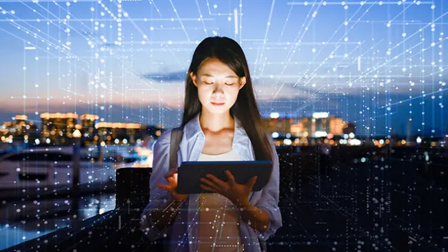 Woman looking at tablet, surrounded by a digital grid