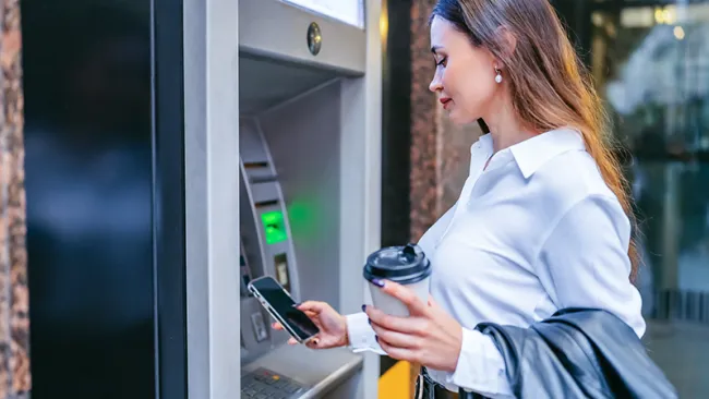 A woman standing in front of an ATM 