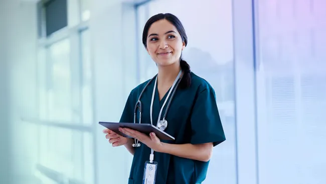 A healthcare professional holding an iPad or tablet