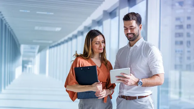 A man and a woman discussing something in the hallway