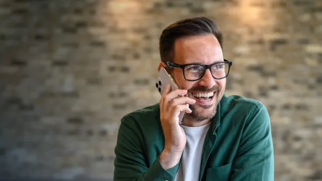 Man smiling while talking on his phone