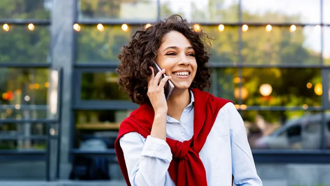 A woman with a curly hair talking to someone over the phone