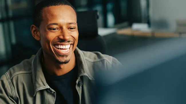 Man sitting at a computer smiling 