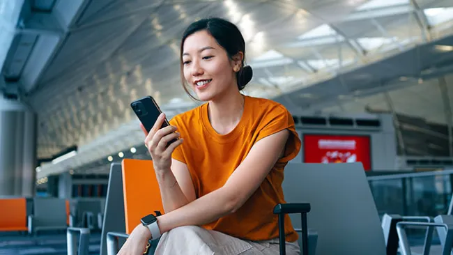 Woman looking at a smartphone in an airport 