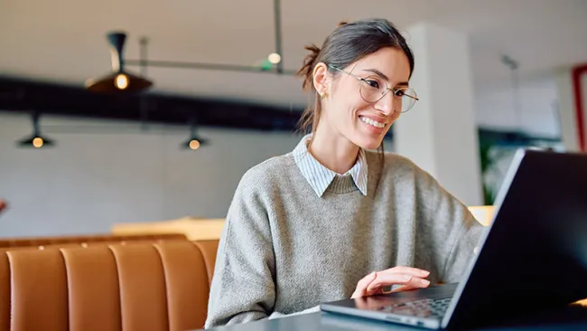 A woman focused on her laptop in a cozy setting 