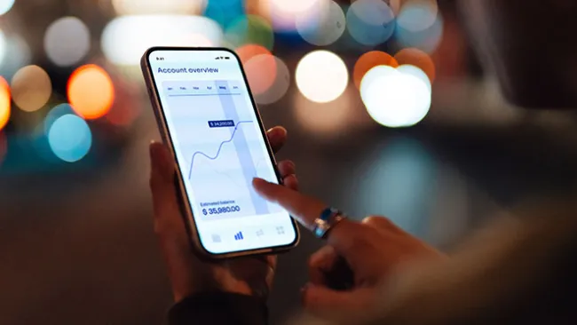 closeup of a hand holding a cellphone open to a banking app