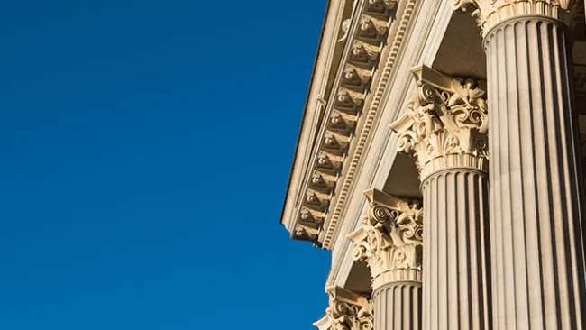 White facade of a government building with columns 