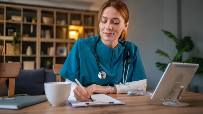 doctor at a desk writing something down