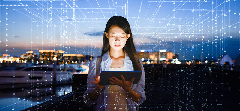 Woman looking at tablet, surrounded by a digital grid