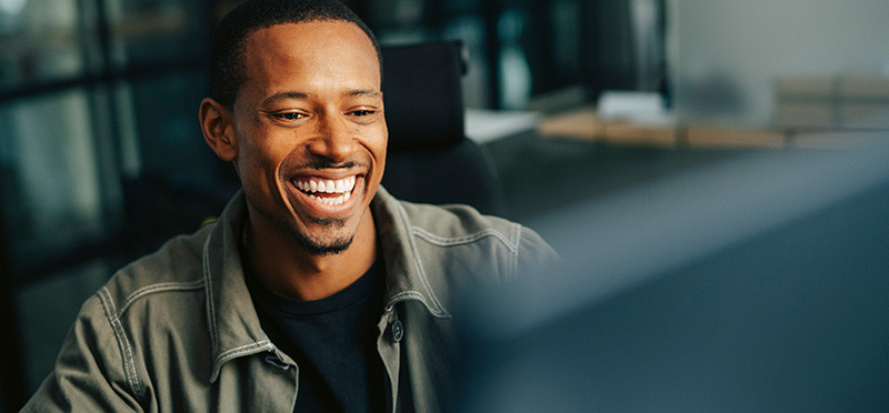 Man sitting at a computer smiling 