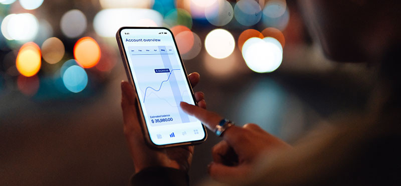 closeup of a hand holding a cellphone open to a banking app