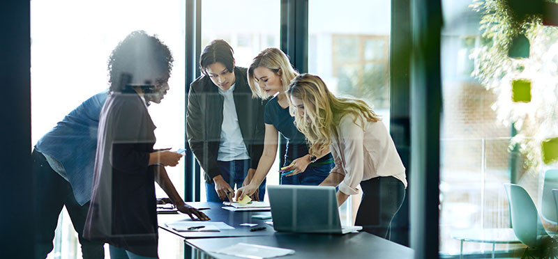 People standing around a desk, collaborating