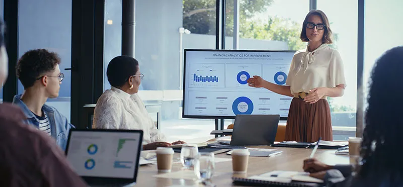 team of salespeople looking at charts on computer screens