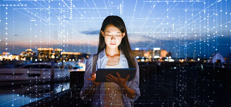 Woman looking at tablet, surrounded by a digital grid