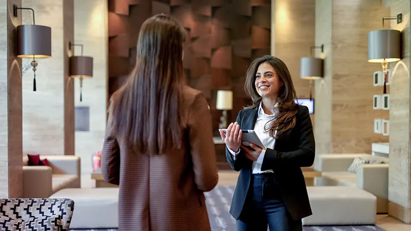 Two women talking in what appears to be a modern hotel lobby