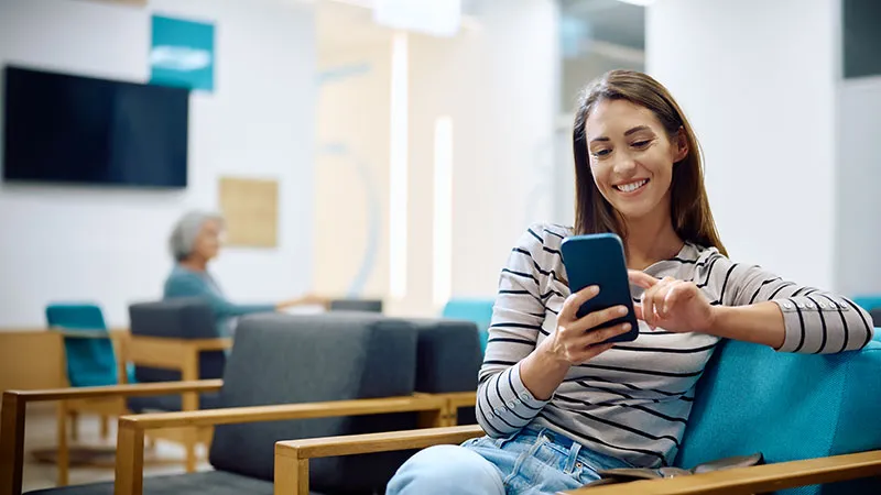 A young woman in a lounge focused on her phone