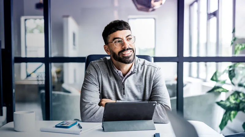 A man in a modern office that is seemingly contemplating about something