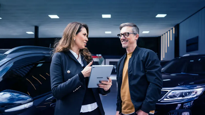A man and a woman conversing at a dealership
