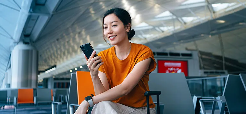 Woman looking at a smartphone in an airport 