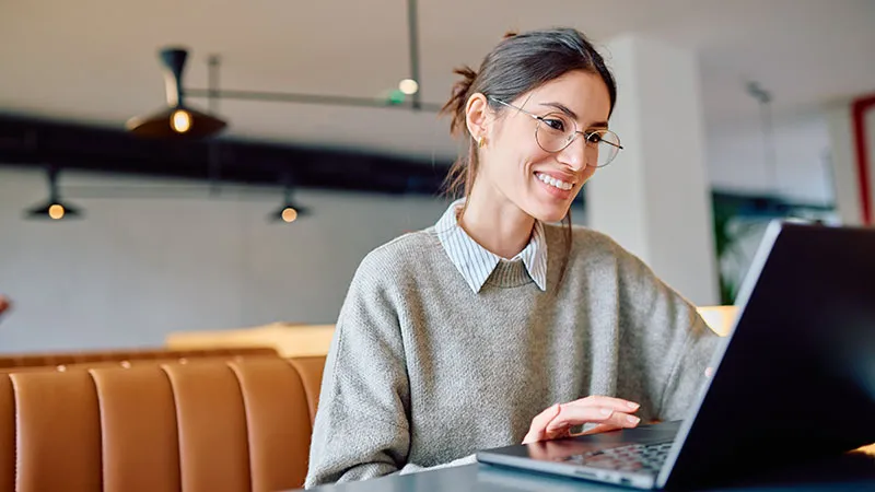 A woman focused on her laptop in a cozy setting 