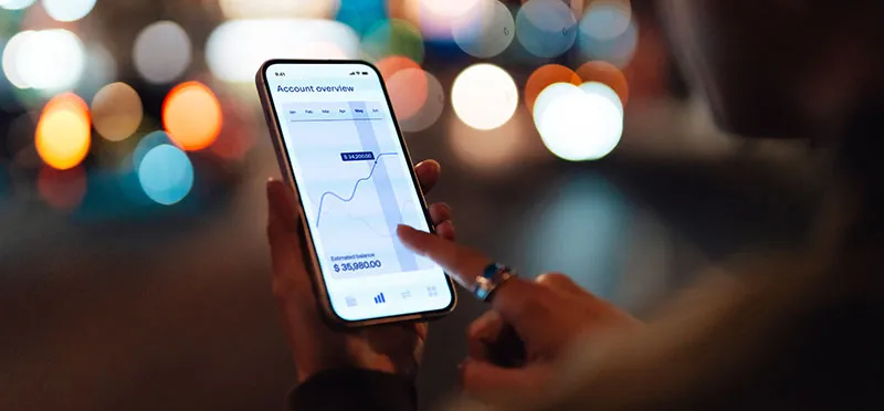 closeup of a hand holding a cellphone open to a banking app