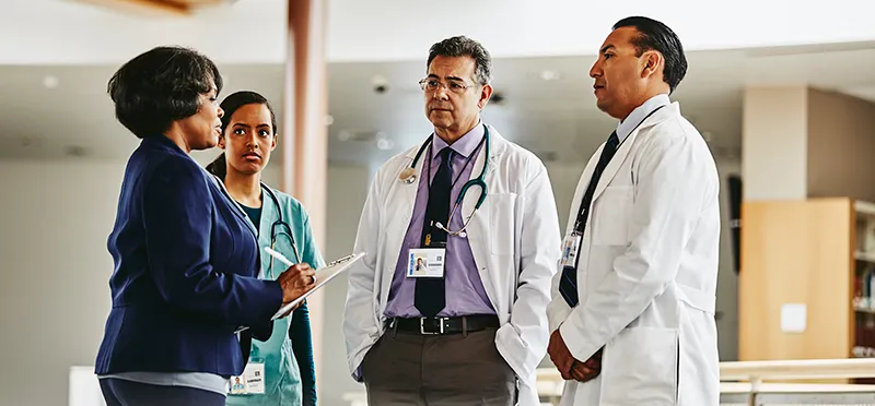 A female patient talking to two doctors and a nurse 