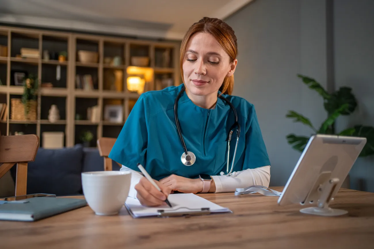 doctor at a desk writing something down